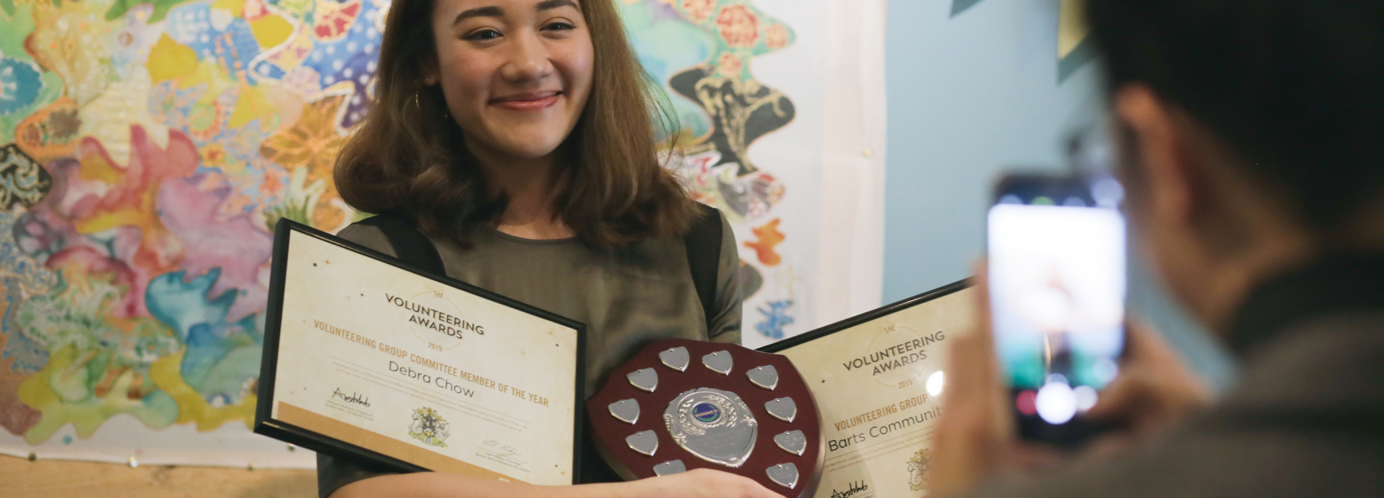 Woman holding certificate and award