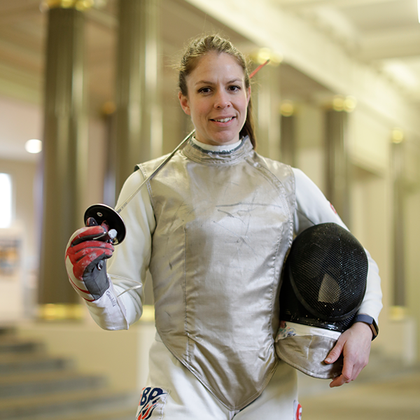 Emily Goodchild wearing her fencing gear and smiling at the camera